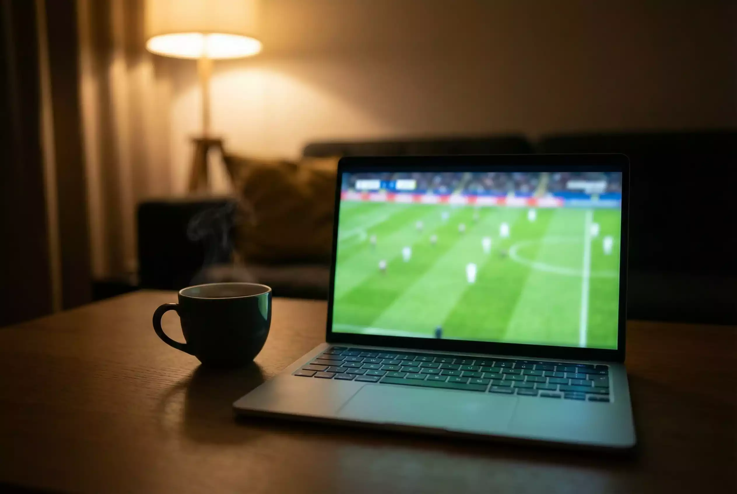 Ecrã de computador portátil a transmitir um evento desportivo ao vivo numa sala